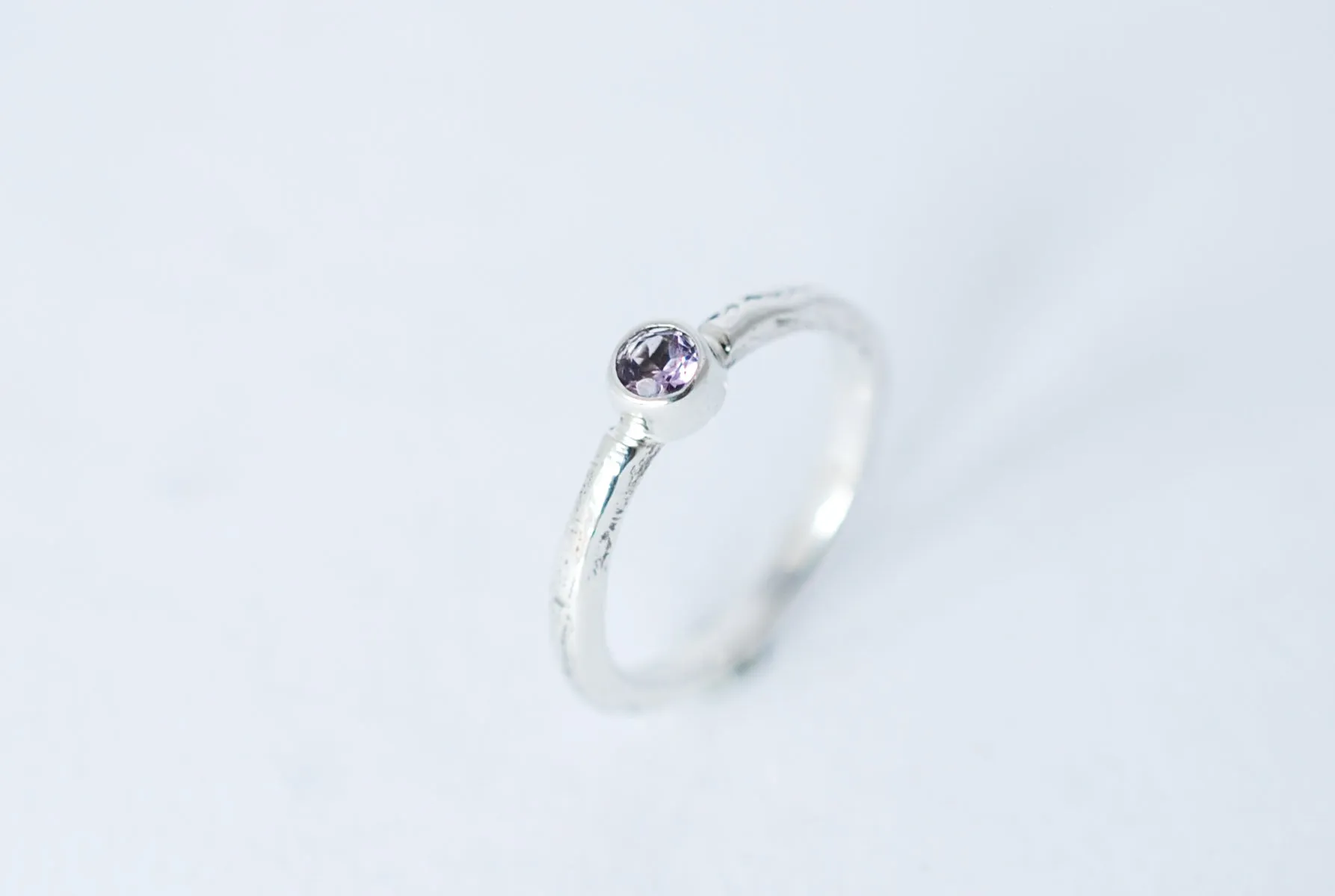 Silver stacking ring with amethyst gemstone.